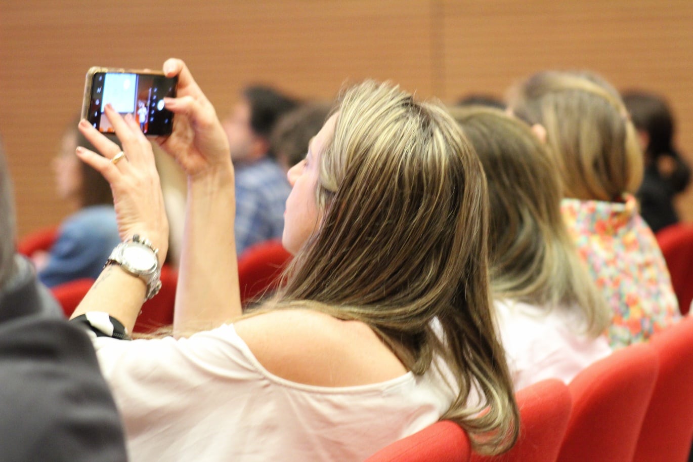 Participante fotografando a apresentação da plateia