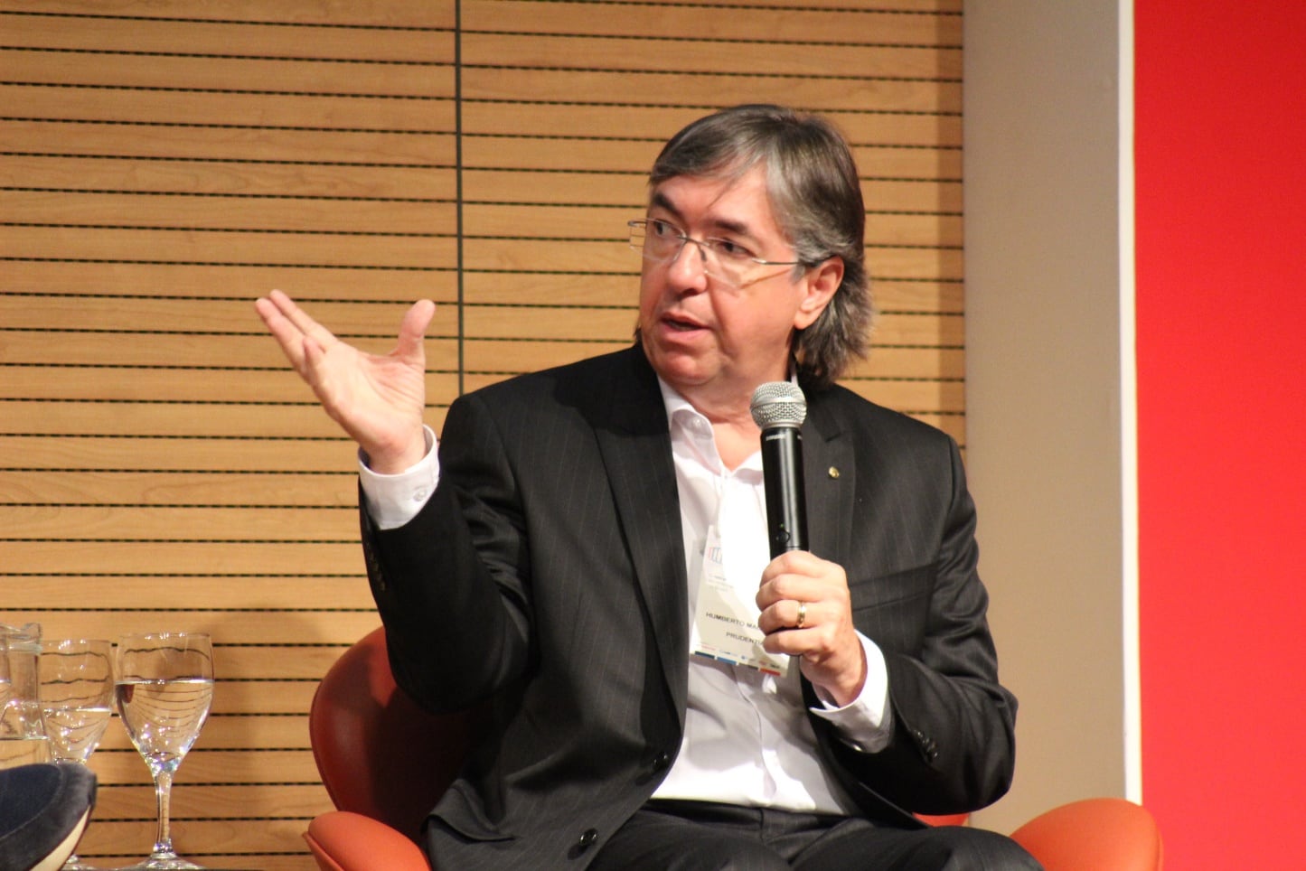 Convidado do painel falando ao microfone no Encontro Executivo de Benchmarking
